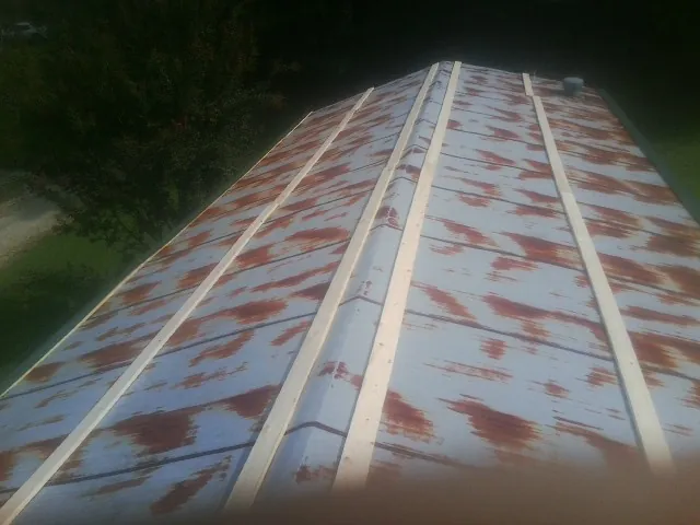 Rusted metal roof panels with new wood purlins before replacement — Storm Damage Roof Repair in Saint Michael by Roofing Brothers